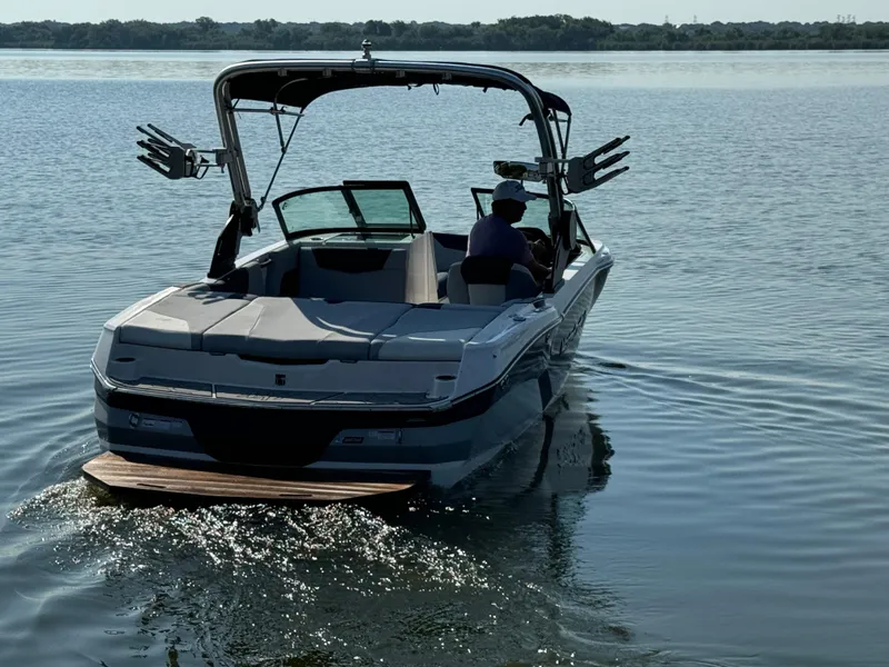 Slide: The Image of 2022 MasterCraft NXT20 boat on calm lake waters, rear view. - 5