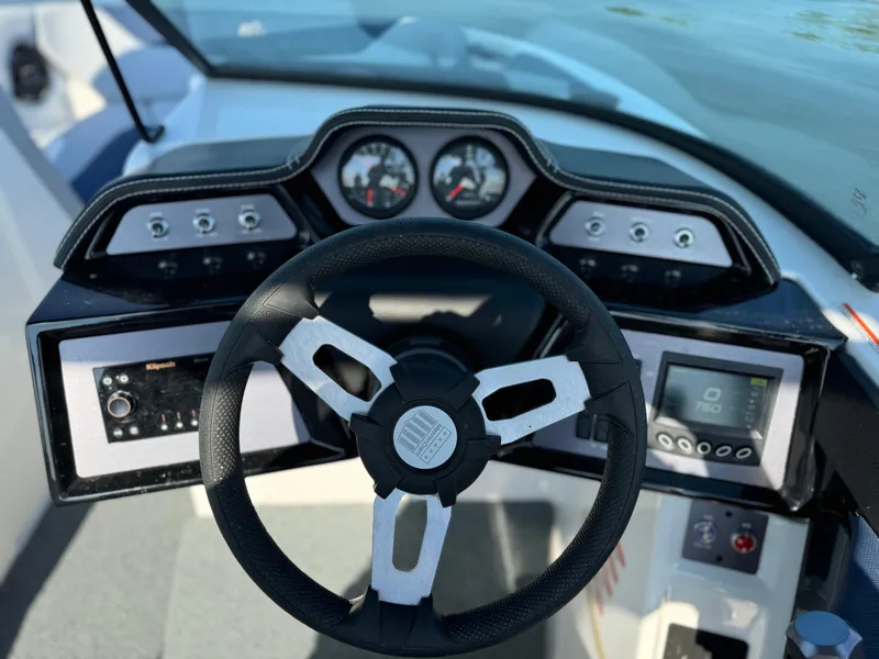 Slide: The Image of 2022 MasterCraft NXT20 boat dashboard with steering wheel and gauges. - 8