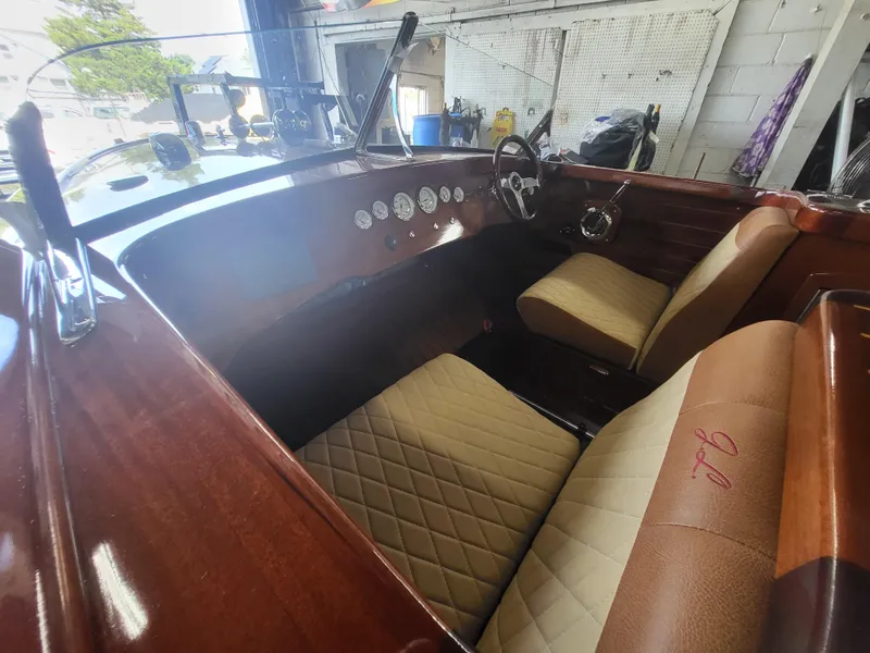 Slide: The Image of Interior of a 2018 Cherubini Classic 24 boat with elegant wood finish and beige seating. - 12