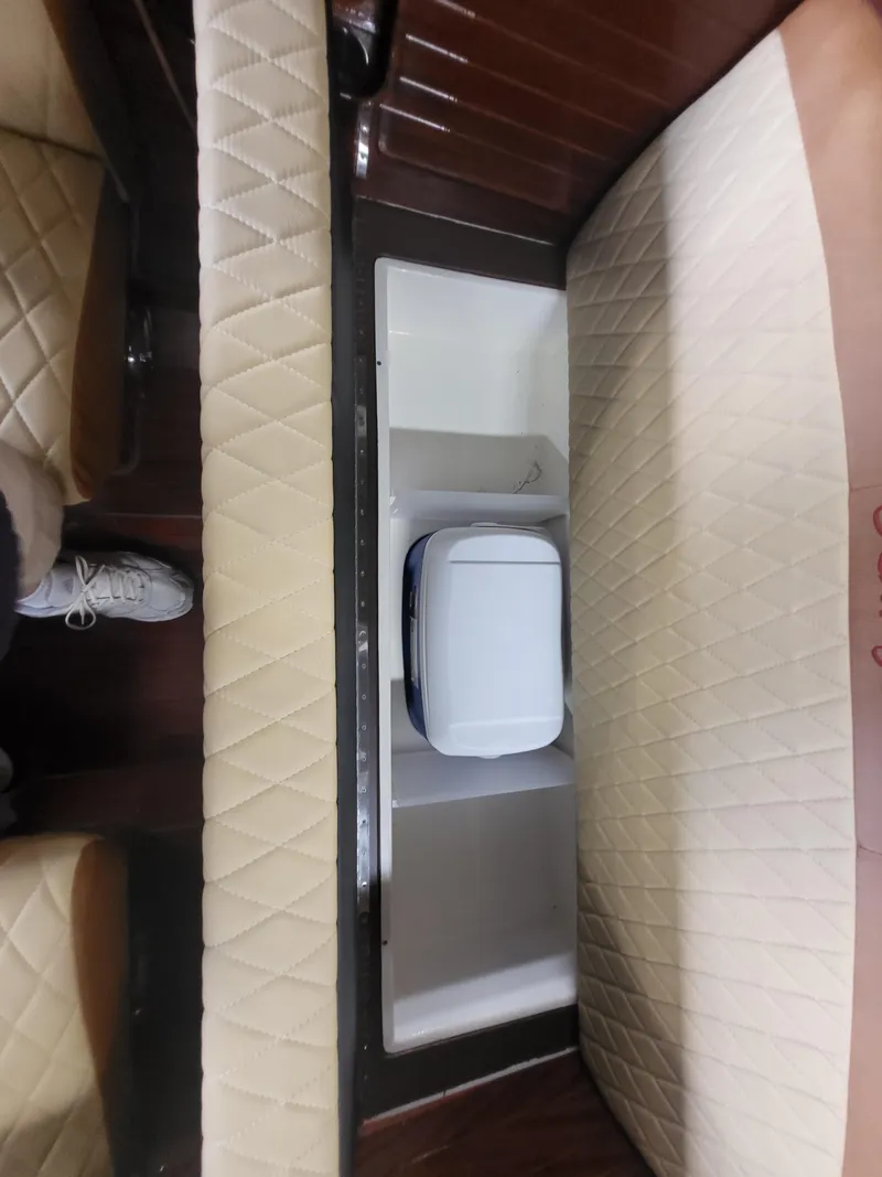 Slide: The Image of Interior of a 2018 Cherubini Classic 24 boat with wooden flooring and storage compartment. - 50