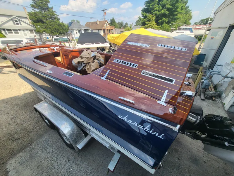 Slide: The Image of Cherubini Classic 24 boat, 2018 model, on trailer, showcasing sleek wooden deck design. - 55