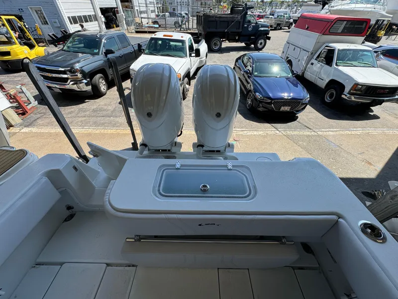 Slide: The Image of 2024 Contender 25 Tournament boat with dual engines, parked near vehicles. - 4