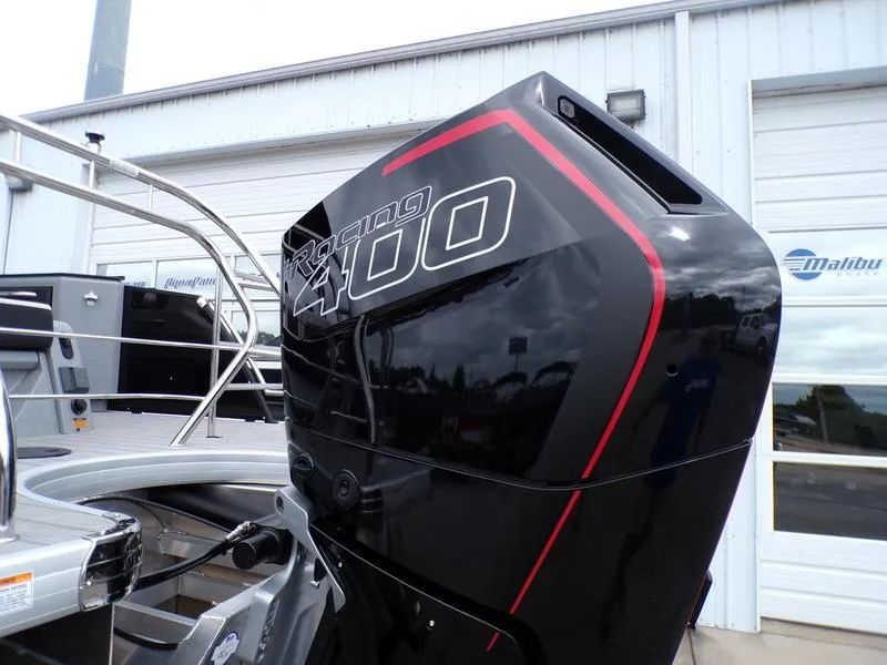 Slide: The Image of 2025 Godfrey Sanpan 2700 with Racing 400 engine, docked near a building. - 3