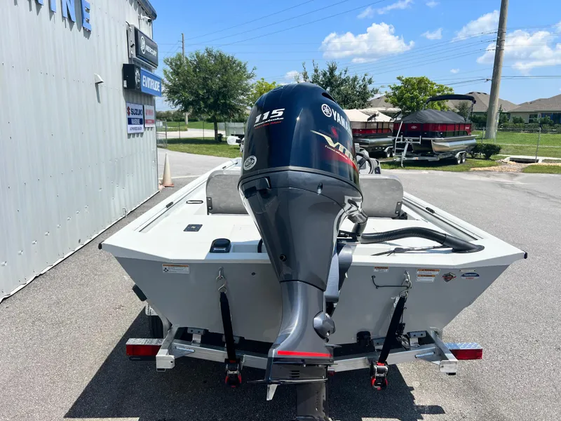 Slide: The Image of 2025 Avid 18SC Rouge boat with Yamaha 115 outboard motor, parked outdoors. - 14