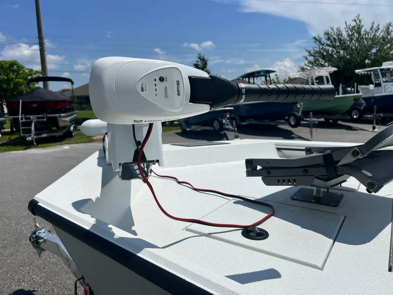 Slide: The Image of 2025 Avid 18SC Rouge boat with trolling motor in a marina setting. - 3