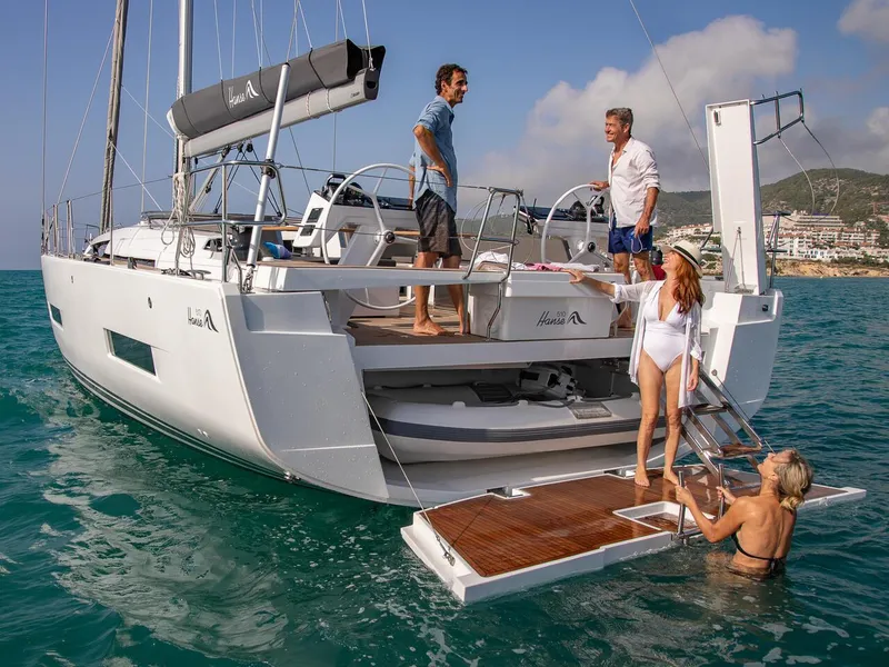 Slide: The Image of 2025 Hanse 510 yacht with people enjoying the deck and swim platform. - 23