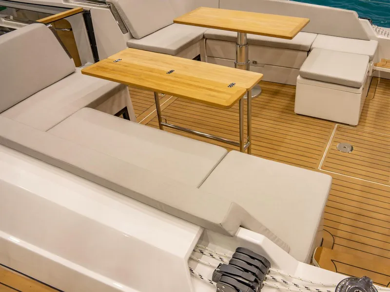 Slide: The Image of Spacious seating area on 2025 Hanse 510 yacht with wooden tables and cushioned benches. - 6