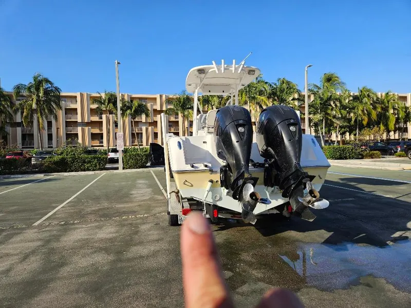 Slide: The Image of 2013 Tidewater 250 CC Adventure boat with dual engines in a sunny parking lot. - 12