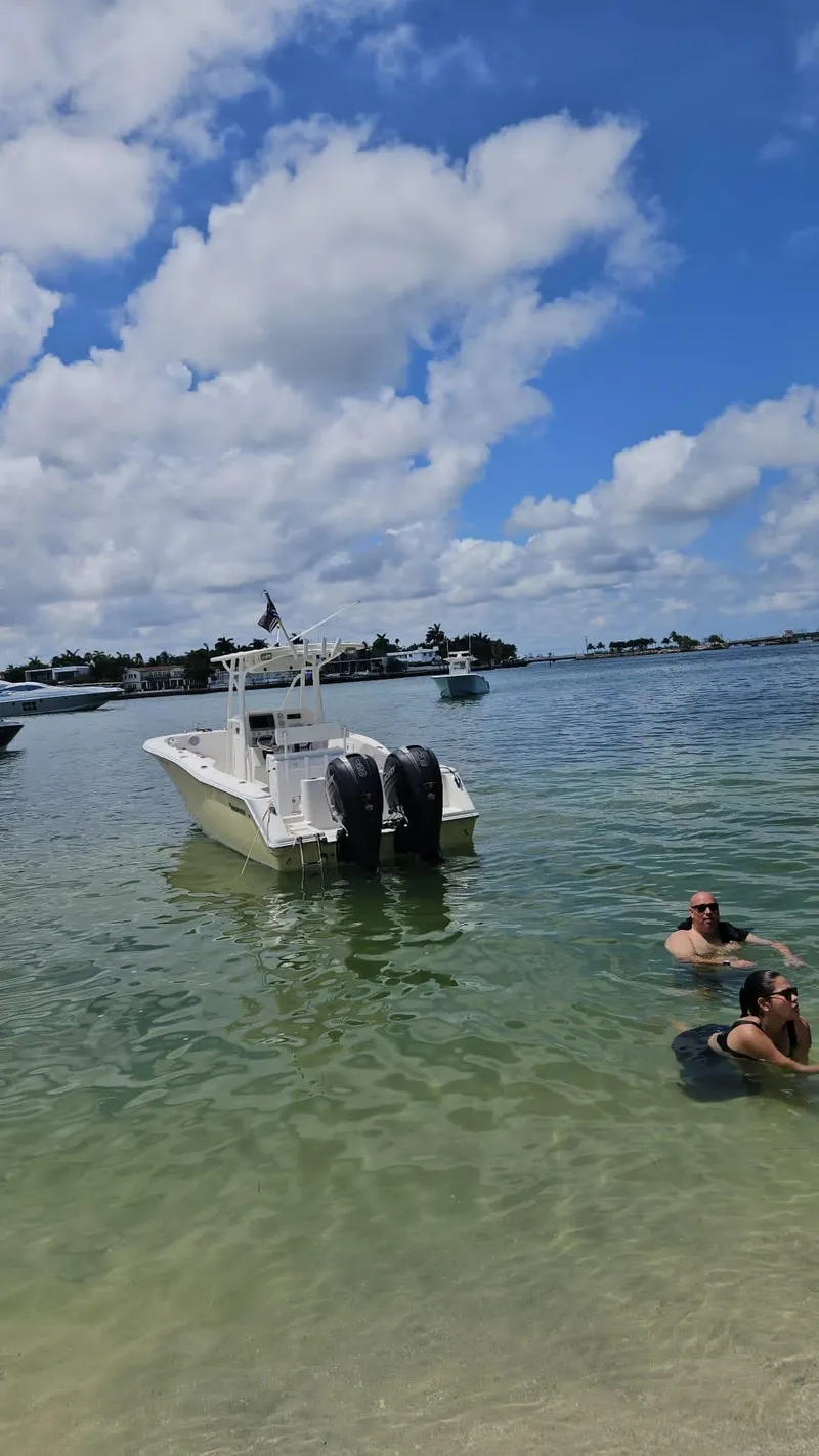 Slide: The Image of 2013 Tidewater 250 CC Adventure boat in clear water with people swimming nearby. - 29