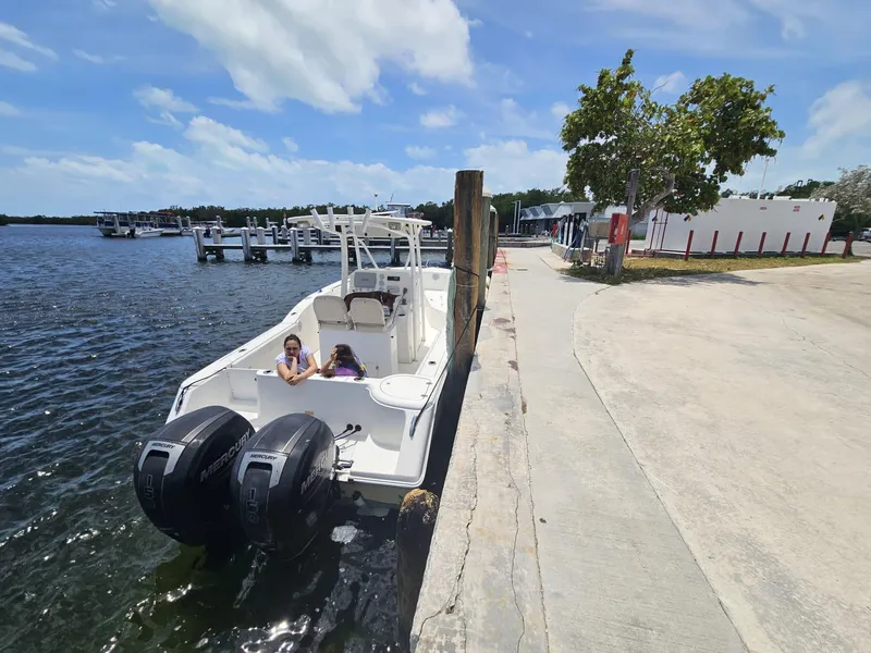 Slide: The Image of 2013 Tidewater 250 CC Adventure boat docked at marina under blue sky. - 4