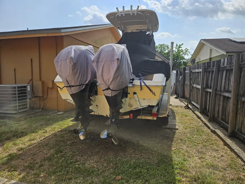 Slide: The Image of 2013 Tidewater 250 CC Adventure boat with dual engines, parked in a residential yard. - 40