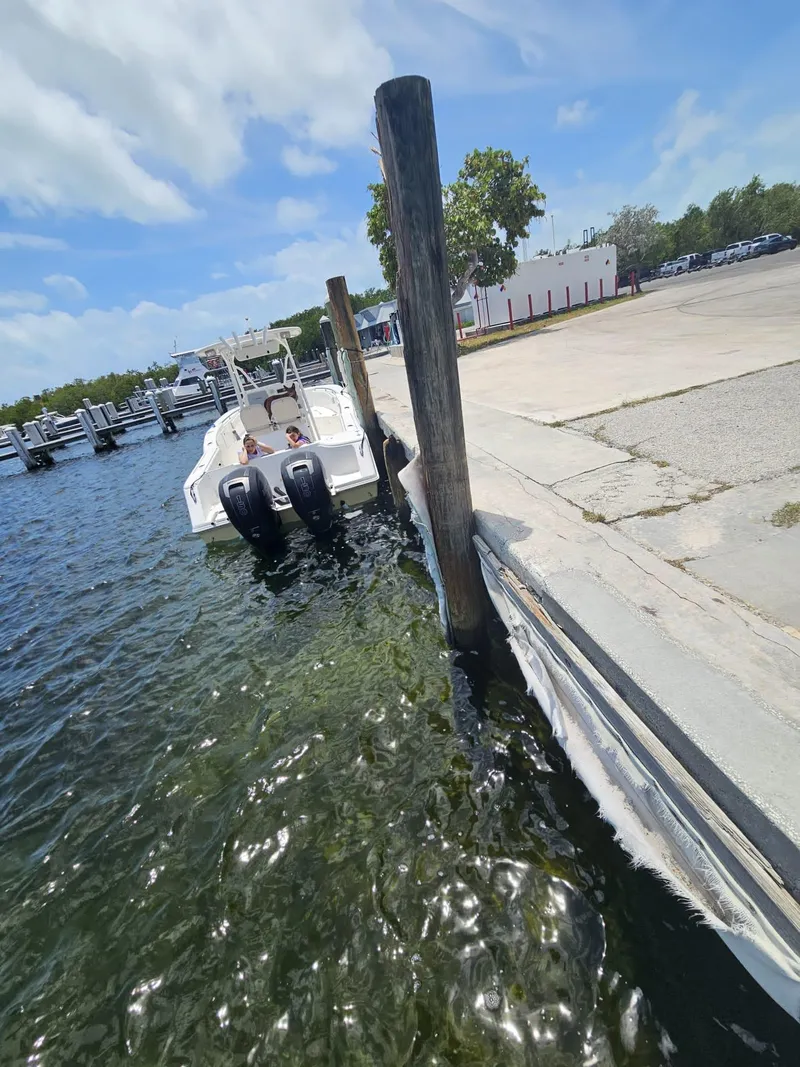 Slide: The Image of 2013 Tidewater 250 CC Adventure docked at marina under clear blue sky. - 49