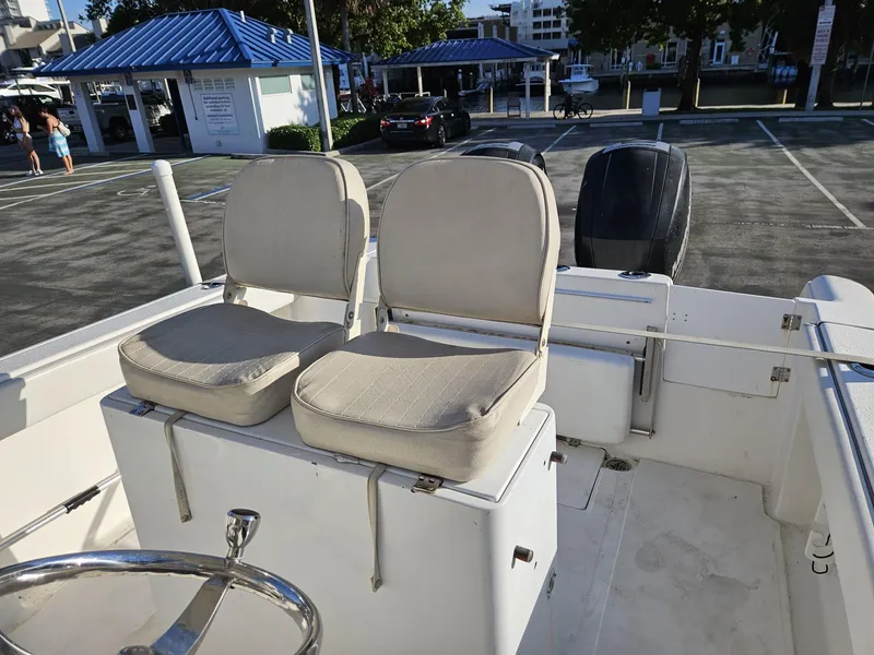 Slide: The Image of 2013 Tidewater 250 CC Adventure boat with dual seats and steering wheel in a parking lot. - 9
