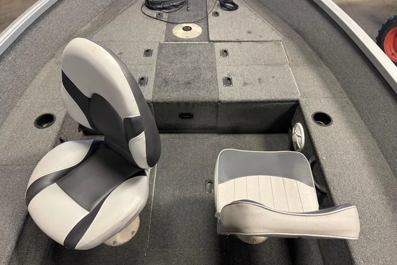 Slide: The Image of 2014 Alumacraft Voyageur 175 Tiller boat interior with two seats and carpeted flooring. - 11
