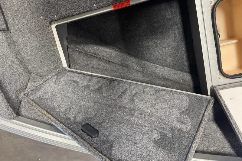 Slide: The Image of 2014 Alumacraft Voyageur 175 Tiller boat storage compartment with open hatch. - 16