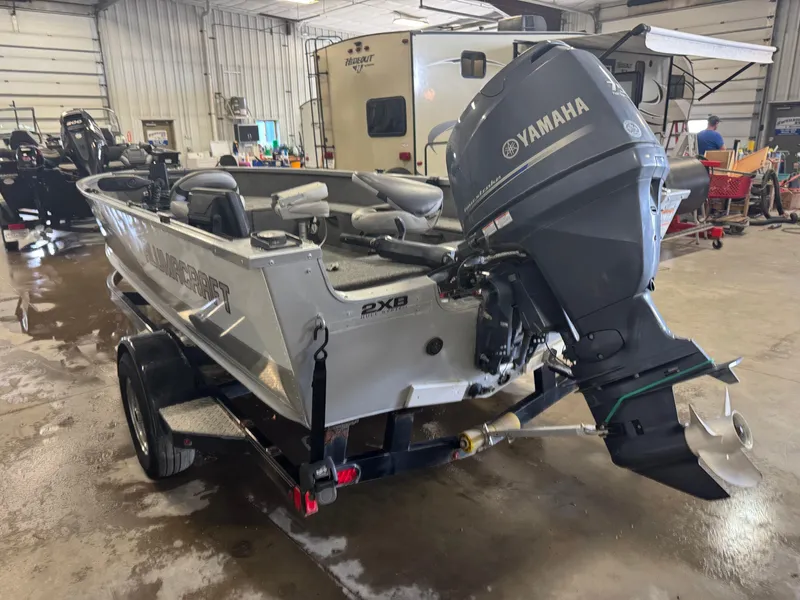 Slide: The Image of 2014 Alumacraft Voyageur 175 Tiller boat with Yamaha outboard motor in a garage. - 4