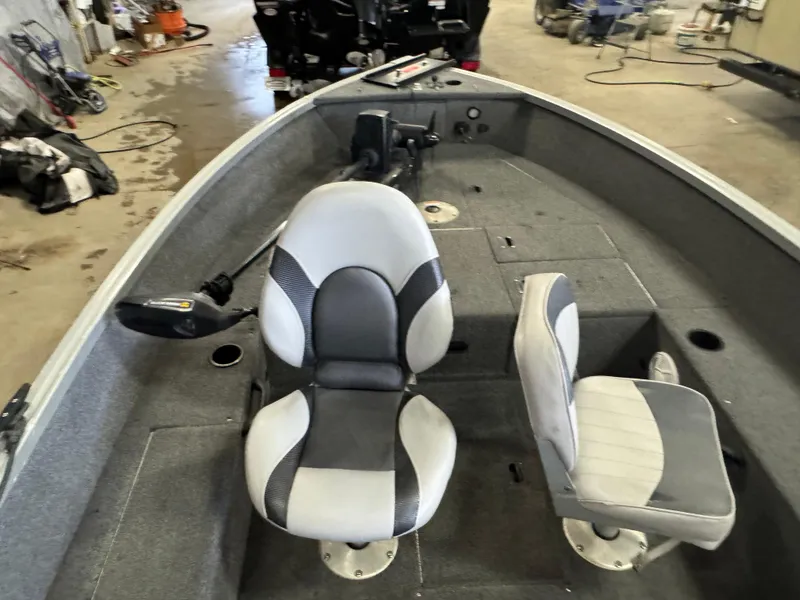 Slide: The Image of 2014 Alumacraft Voyageur 175 Tiller boat battery compartment with wiring and carpeted interior. - 9