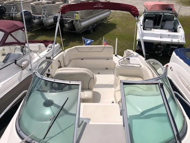 Slide: The Image of 2007 Monterey 250 Cruiser boat with open deck and seating, docked among other boats. - 13