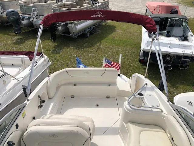 Slide: The Image of 2007 Monterey 250 Cruiser boat interior with seating and canopy, docked near other boats. - 14