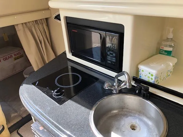 Slide: The Image of 2007 Monterey 250 Cruiser kitchenette with microwave, sink, and stove. - 16