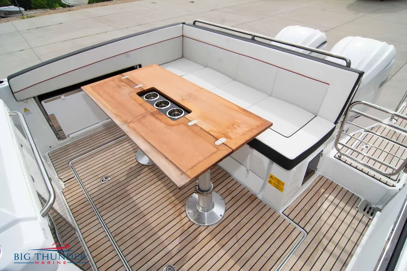 Slide: The Image of 2024 Jeanneau Leader 9.0 WA boat deck with seating and wooden table. - 16