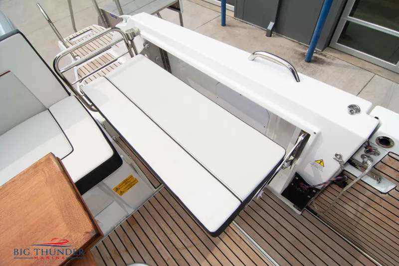 Slide: The Image of 2024 Jeanneau Leader 9.0 WA boat deck with foldable seating and wooden flooring. - 17