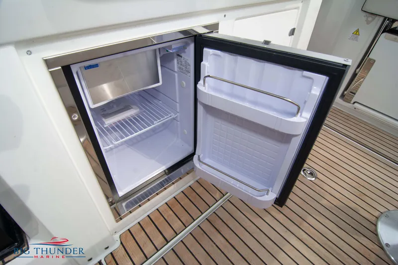 Slide: The Image of 2024 Jeanneau Leader 9.0 WA boat with open mini fridge on deck. - 24