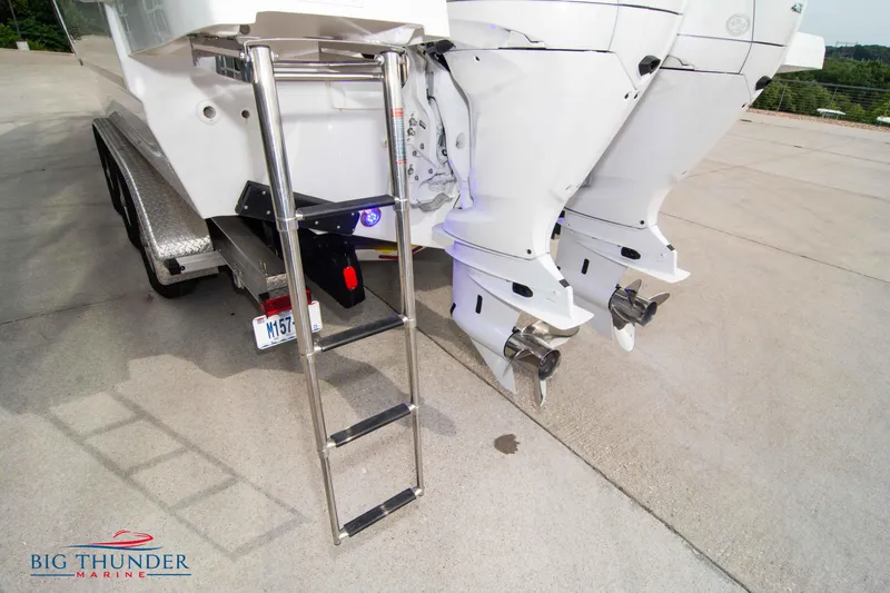 Slide: The Image of 2024 Jeanneau Leader 9.0 WA boat with dual outboard motors and boarding ladder. - 9