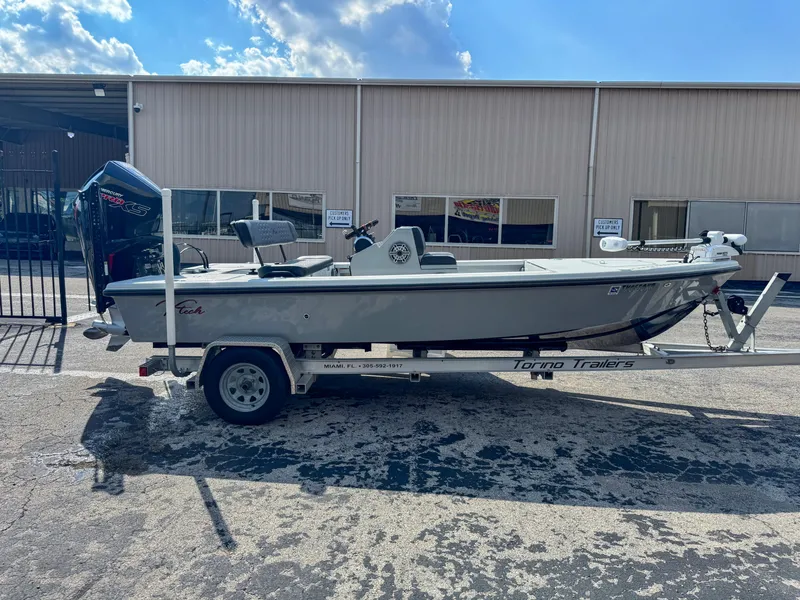 Slide: The Image of Vtech 18Flats 2022 boat on trailer, parked outside a warehouse under a blue sky. - 5