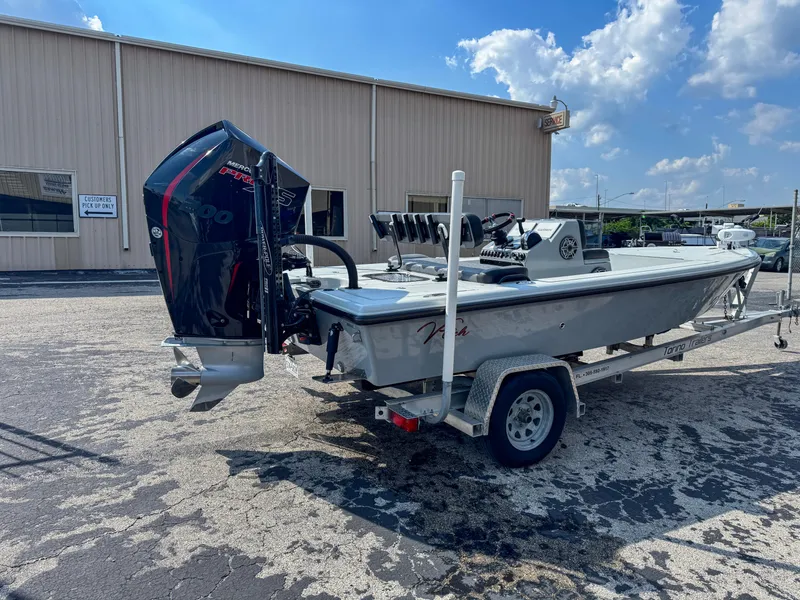 Slide: The Image of Vtech 18Flats 2022 boat on trailer, parked outside a warehouse under a blue sky. - 6