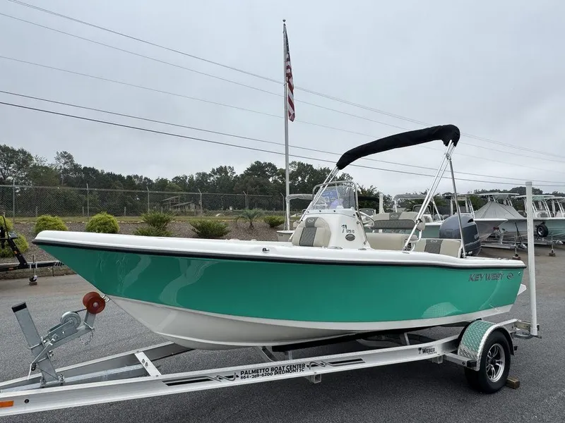 The Image of 2025 Key West 179 FS boat on trailer, teal hull, black canopy, parked outdoors. - 1