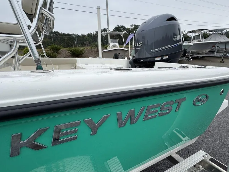 Slide: The Image of 2025 Key West 179 FS boat with Yamaha 115 engine, teal hull, in a marina setting. - 26