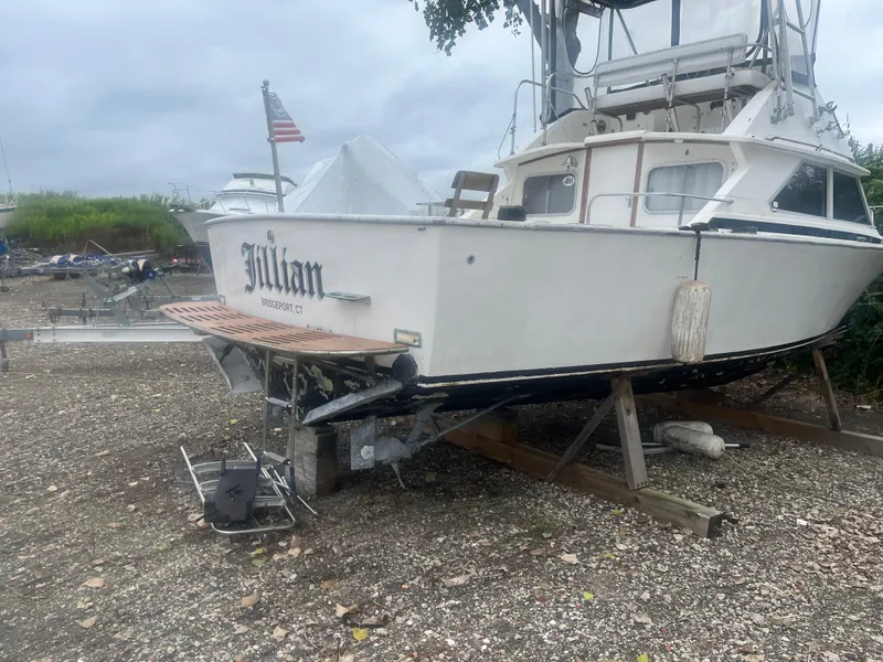 Slide: The Image of 1973 Bertram 28 Flybridge Cruiser on dry land, rear view. - 1