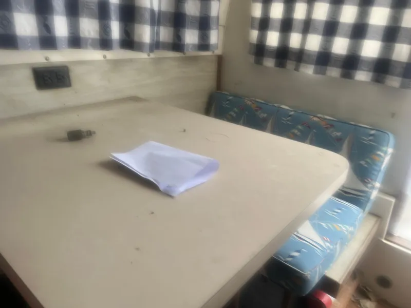 Slide: The Image of Interior of 1973 Bertram 28 Flybridge Cruiser with table and patterned seating. - 12