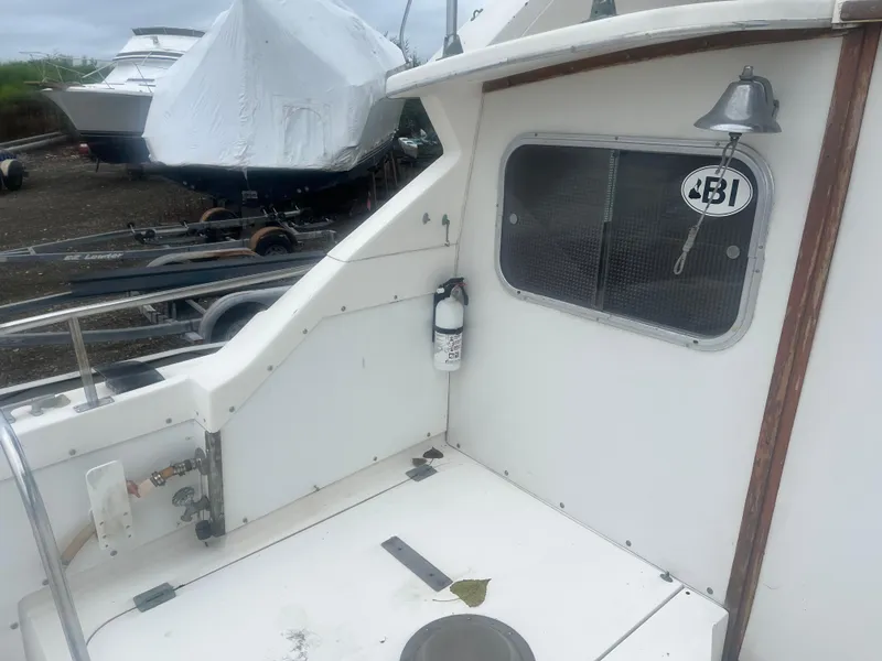 Slide: The Image of 1973 Bertram 28 Flybridge Cruiser deck with window and bell. - 19
