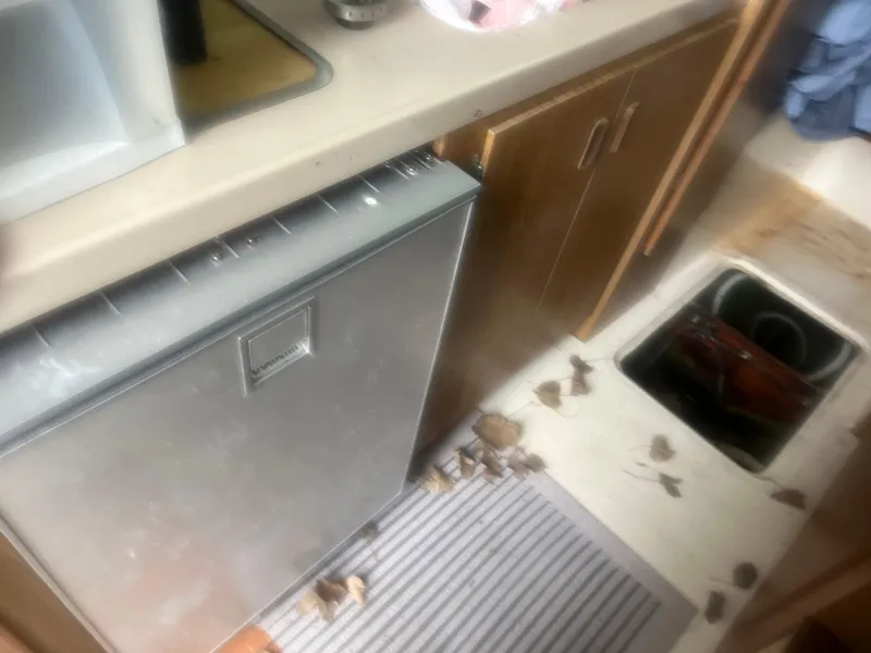 Slide: The Image of Interior of 1973 Bertram 28 Flybridge Cruiser with kitchen area and open floor compartment. - 23