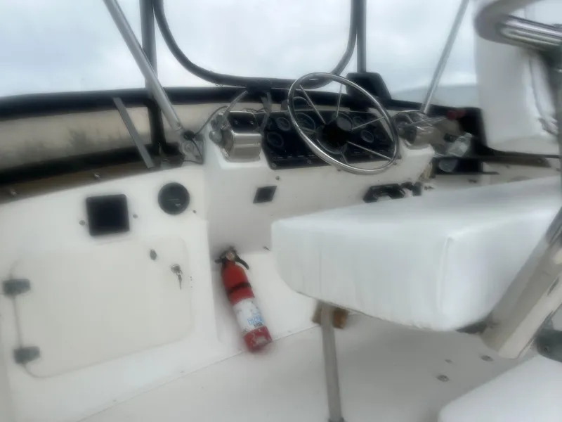 Slide: The Image of 1973 Bertram 28 Flybridge Cruiser helm with steering wheel and controls. - 3