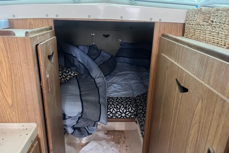 Slide: The Image of 1973 Bertram 28 Flybridge Cruiser cabin with cozy bedding and wooden interior. - 37