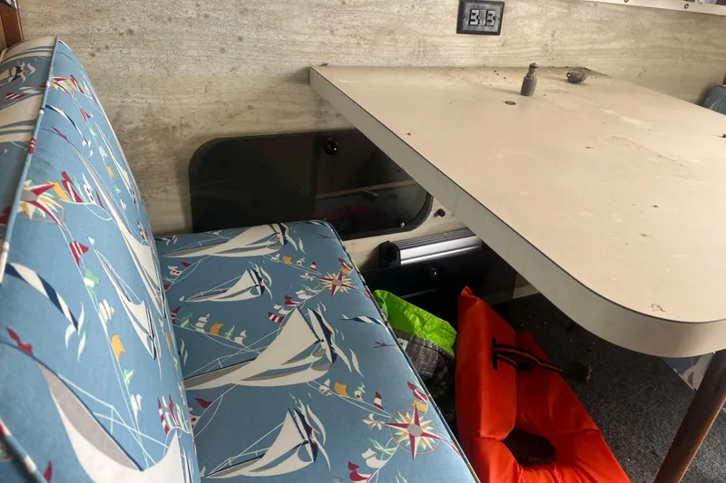 Slide: The Image of 1973 Bertram 28 Flybridge Cruiser interior with nautical-themed upholstery and table. - 38