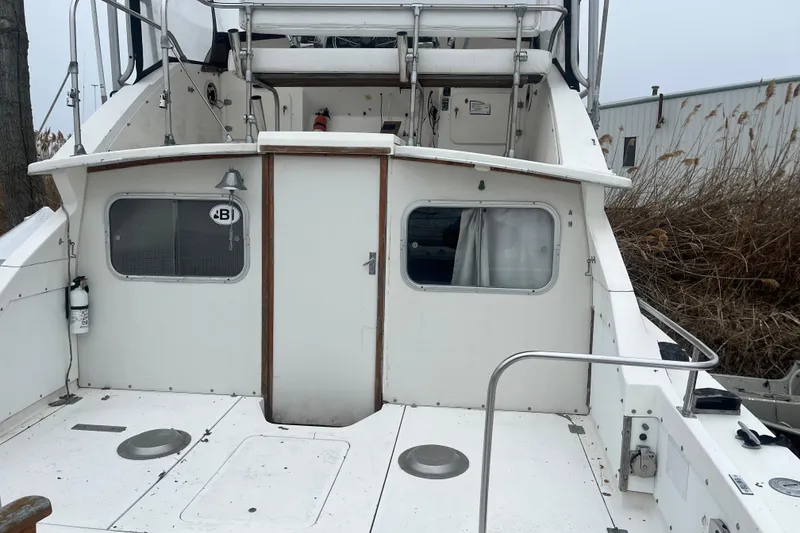 Slide: The Image of 1973 Bertram 28 Flybridge Cruiser, rear view, showcasing deck and cabin entrance. - 45