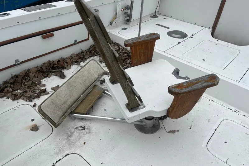 Slide: The Image of 1973 Bertram 28 Flybridge Cruiser with worn fishing chair and fallen leaves on deck. - 48
