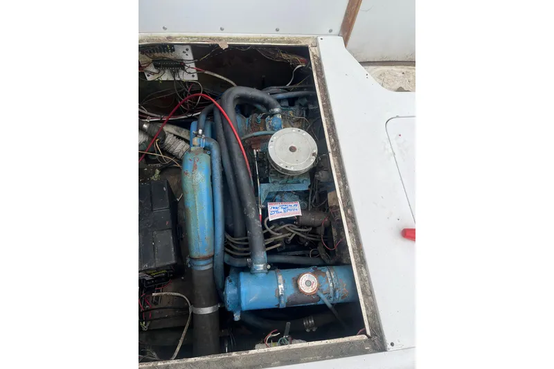 Slide: The Image of Engine compartment of a 1973 Bertram 28 Flybridge Cruiser, showing mechanical components and wiring. - 52