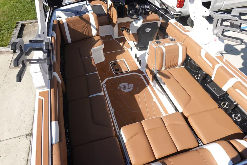Slide: The Image of 2025 Malibu Wakesetter 25 LSV interior with brown seating and modern design. - 12
