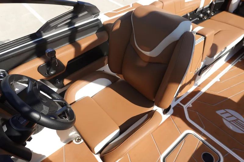 Slide: The Image of 2025 Malibu Wakesetter 25 LSV interior with brown leather seats and steering wheel. - 21