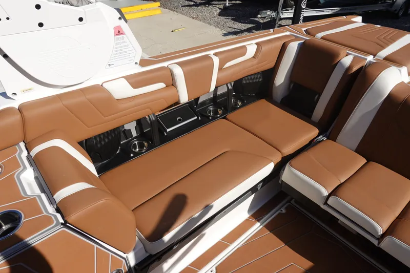 Slide: The Image of 2025 Malibu Wakesetter 25 LSV interior with brown and white seating, cup holders. - 25