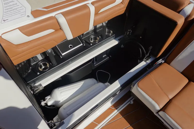 Slide: The Image of 2025 Malibu Wakesetter 25 LSV interior storage with tan and white seating. - 26