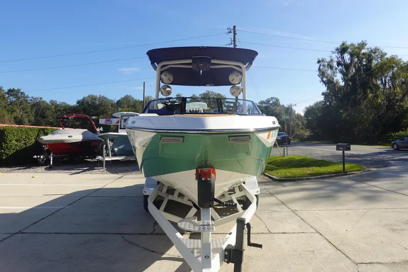 Slide: The Image of 2025 Malibu Wakesetter 25 LSV boat on trailer, parked outdoors under clear sky. - 3