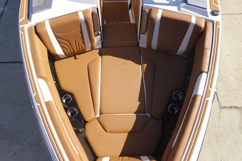 Slide: The Image of 2025 Malibu Wakesetter 25 LSV boat interior with tan leather seating and cup holders. - 37