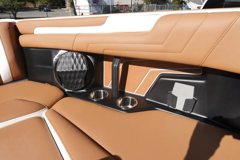 Slide: The Image of 2025 Malibu Wakesetter 25 LSV interior with tan seating, cup holders, and speaker. - 39