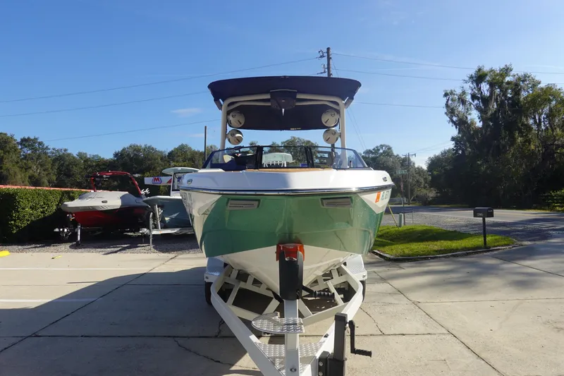 Slide: The Image of 2025 Malibu Wakesetter 25 LSV boat on trailer, parked outdoors under clear sky. - 4